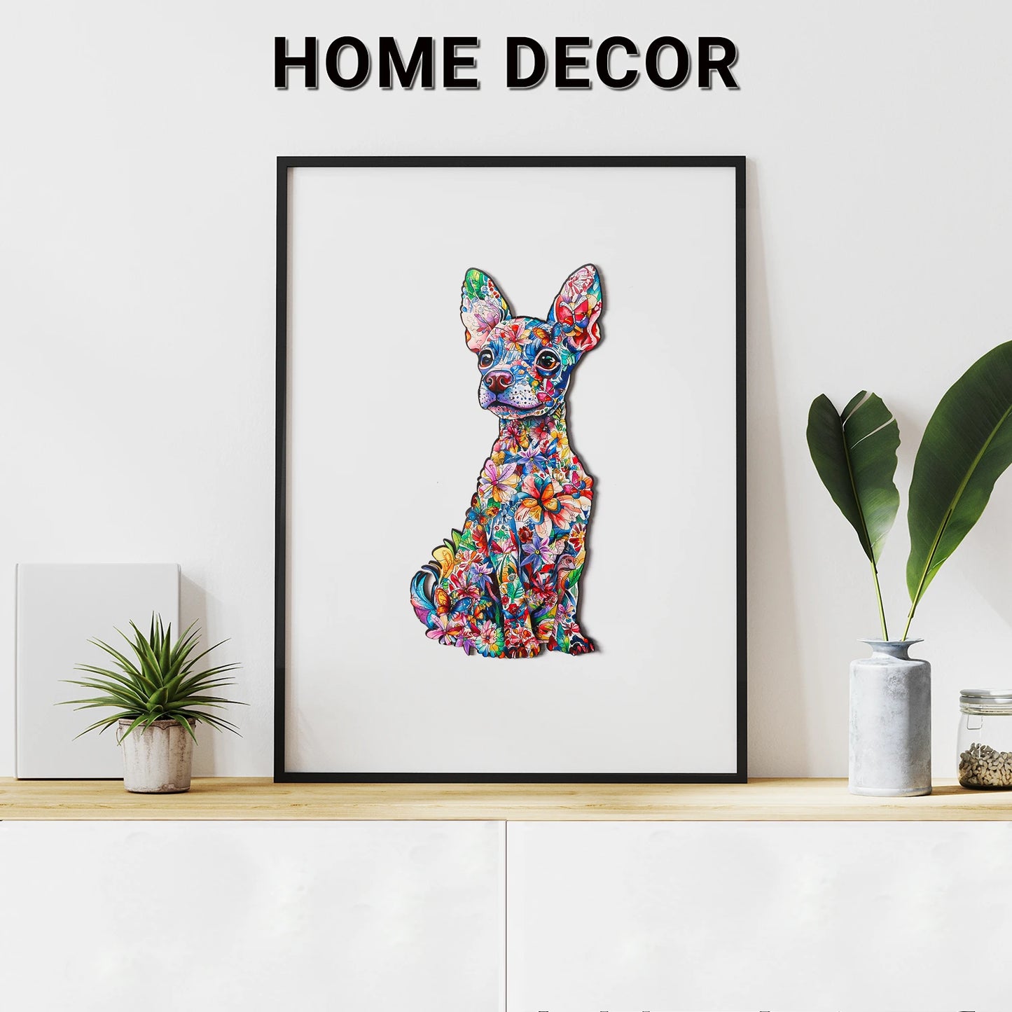 A framed illustration of a colorful dog, reminiscent of the charm found in lycheepuzzles' Dachshund Puzzle Animal Dog Wooden Puzzles for Adults (200 Pieces), rests on a cabinet adorned with small potted plants. The words "Home Decor" appear above.