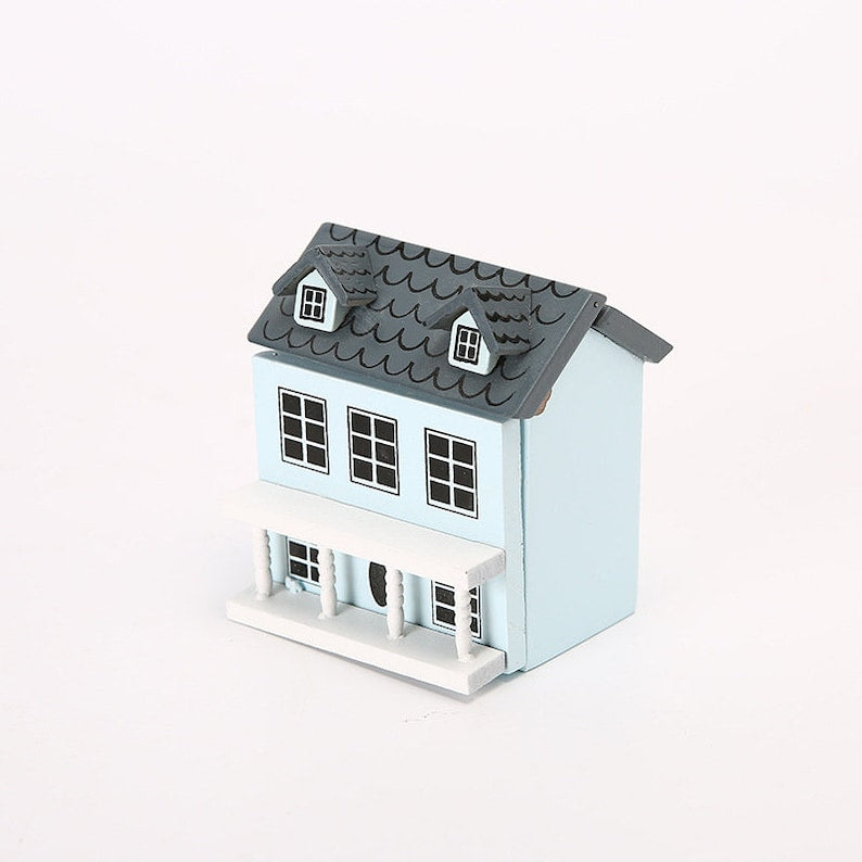 The lycheepuzzles 1:12 Dollhouse Miniature Wooden Little House, from the brand lycheepuzzles, is a delightful pale blue dollhouse featuring a gray roof. It is expertly crafted from quality wood materials and includes a welcoming front porch along with multiple windows.